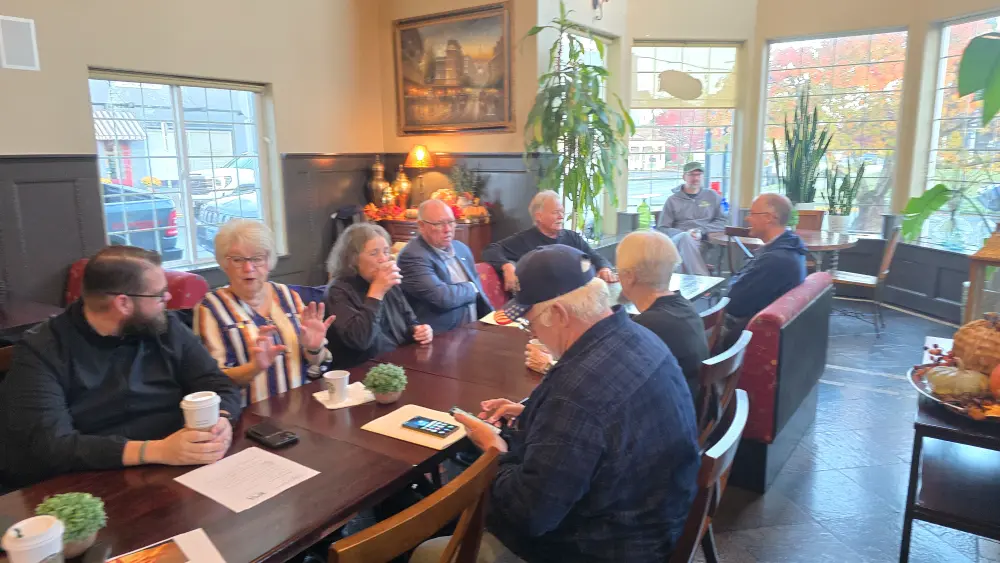 A large group of adults are at a local restaurant having a meeting about Silverton's Chamber of Commerce, how to support local, small businesses, organizing for businesses, business networking, and more in Oregon's Garden City Silverton Chamber of Commerce.