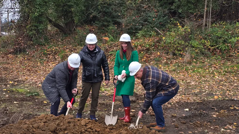Four members, two adult females and 2 adult males all wearing white hard hats, 3 with shovels are breaking ground at the new Edward Jones grounbreaking ceremony. Silverton's Chamber supports local businesses and works with community members and local government officials to support all businesses.