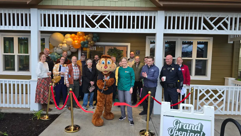 Ribbon cutting at Acorn Dental, a local business in Silverton with a squirrel mascot cutting the ribbon. Members of Silverton's Chamber of Commerce stand with employees at Acorn Dental showing advantages of networking in business, business network support for small business, ways to support small businesses, benefits of being a chamber of commerce member, and community support.